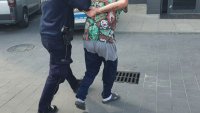 Policjanci prowadzą zatrzymanego mężczyznę