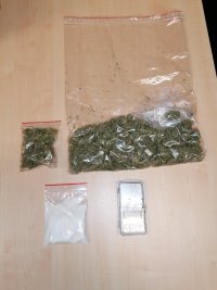 Na zdjęciu widnieją 3 worki strunowe foliowe, jeden z zawartością białego proszku/amfetaminy, dwa pozostałe z suszem marihuany oraz waga.