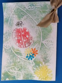 Praca dziecka przedstawia biedronkę i słońce na zielonym tle.