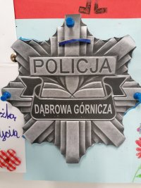 Praca dziecka przedstawia emblemat odznaki policyjnej.