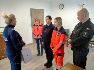 Umundurowany policjant- Pani Komendant wraz z nauczycielami dziękujący uczennicom klas mundurowych o profilu policyjnym i ratownictwa medycznego